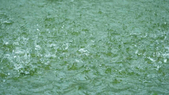雨滴落入水中溅起水花慢镜头