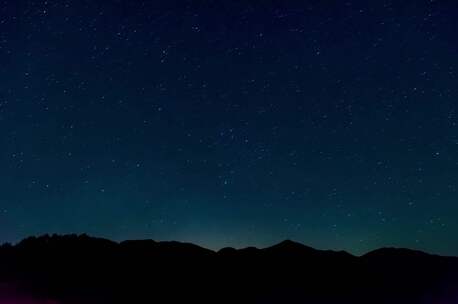 夜空繁星与远处灯火景观