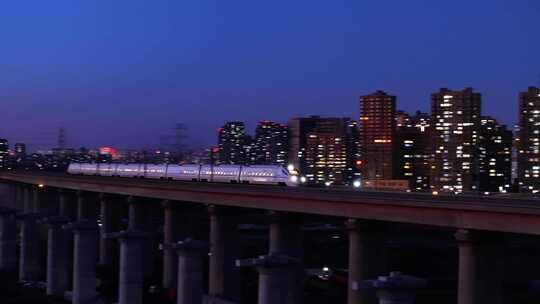 一线城市高铁穿梭在夜晚的城市里