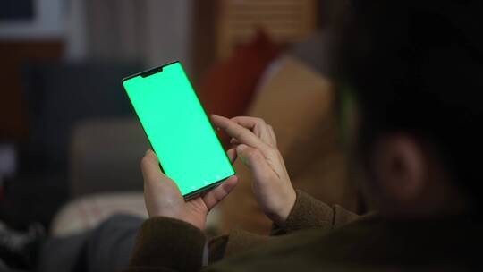 女性居家使用绿色屏幕绿屏抠像替换屏幕手机