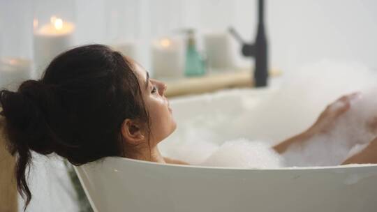 女人躺在浴缸里洗澡视频素材模板下载