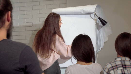 女人在白纸上画画讲解视频素材模板下载