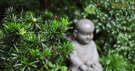 中国杭州永福寺雨天里的小和尚雕像