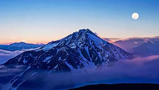 雪山之巅与空中明月的壮丽景观