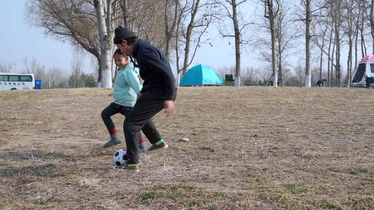 冬季在户外和女儿踢球的父亲视频素材模板下载