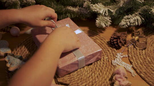 双手系上圣诞礼物的蝴蝶结视频素材模板下载