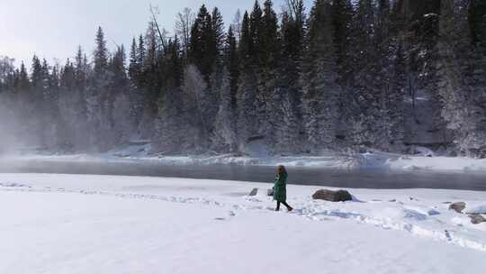 航拍新疆阿勒泰冬季喀纳斯游客在雪地上游玩