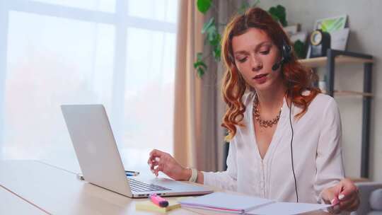 专注女性远程教师在线导师在笔记本电脑上佩戴耳机会议