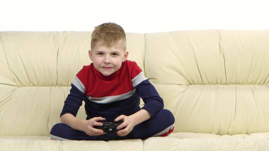 男孩在沙发上玩电子游戏