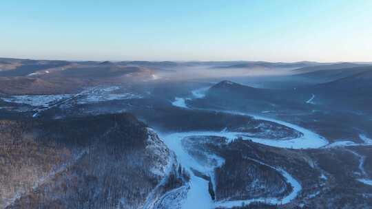 延时航拍黎明时的林海雪原冰封河流