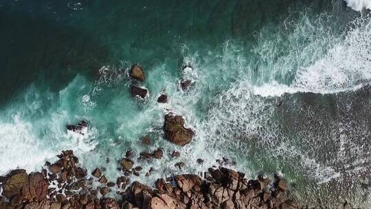 航拍海浪冲向岸边石头