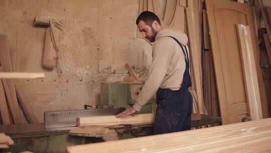 木匠用圆锯打磨木块