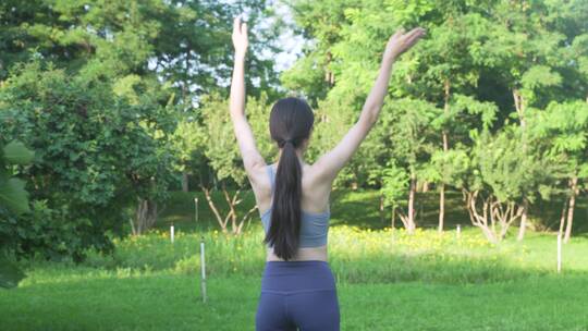 户外草地上做瑜伽的年轻女性身穿运动服装视频素材模板下载