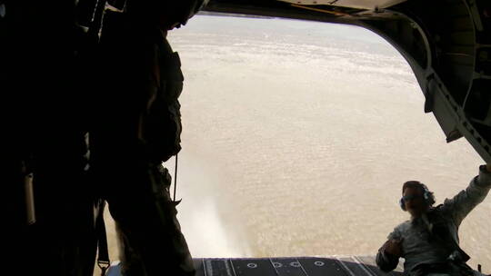 伞兵从低空飞行的直升机跳进河里