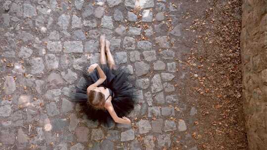 女芭蕾舞艺术家在地面上用手臂表演舞蹈