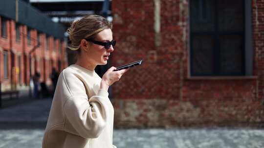 女性在城市散步时使用现代智能手机进行交流