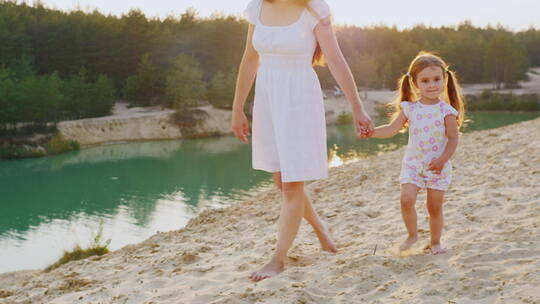 母亲和女儿在湖边散步