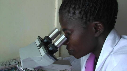 技术员通过显微镜检查标本