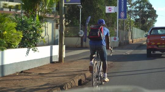 非洲街道上骑自行车的黑种人