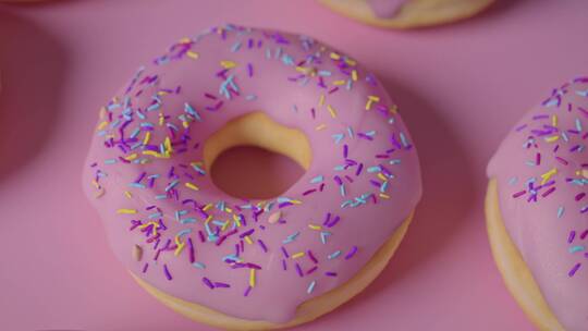 粉色桌子上的甜甜圈特写