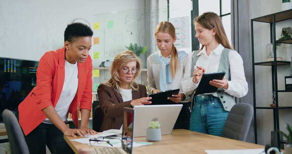 成功的多种族商务女性在办公室一起使用笔记