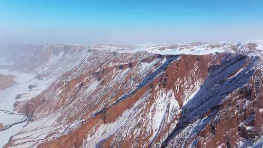 航拍新疆冬季安集海大峡谷红色山脉雪山河流