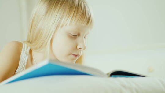 女孩在床上阅读一本书