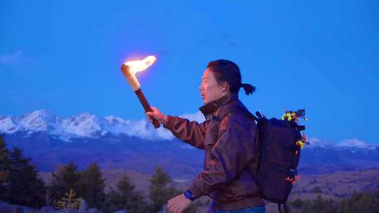 男人打着火把走在雪山前面