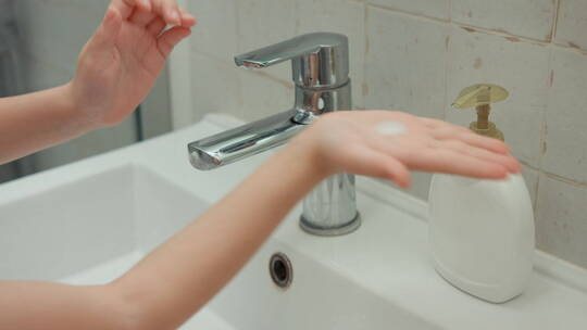 女孩用液体肥皂洗手