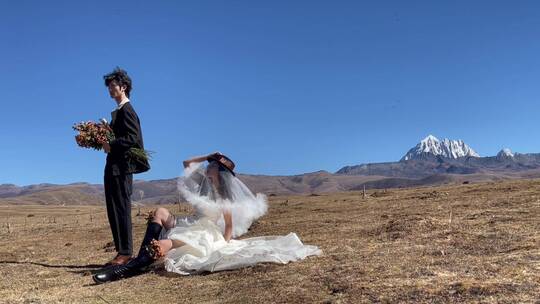 高原枯黄草原雪山拍情侣写真婚纱1视频素材模板下载