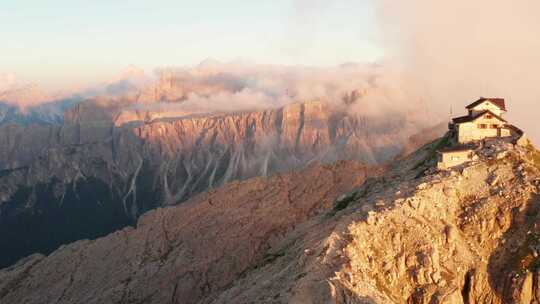 引人注目的悬崖小屋（Rifugio Nuvolau）坐落在Nuvolau山峰上，被日落照亮，意大利