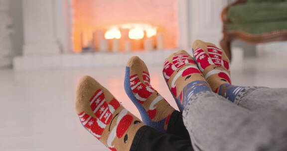 穿着情侣袜的双脚在烤炉前取暖特写