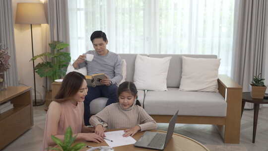 父母和女儿在家通过互联网学习。