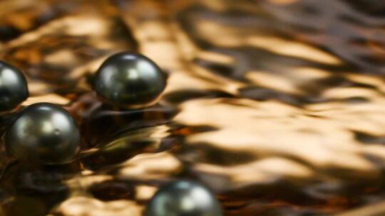 大溪地黑珍珠在金色盘子里的水中滚动