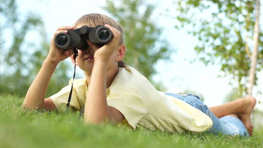男孩用双筒望远镜看远方
