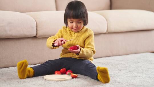 小女孩坐在地板上玩积木玩具