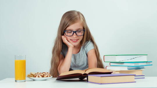 戴眼镜的女生阅读课本并微笑
