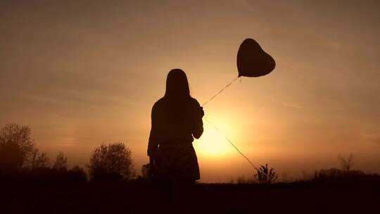 年轻女孩拿着气球进入夕阳的光辉视频素材模板下载