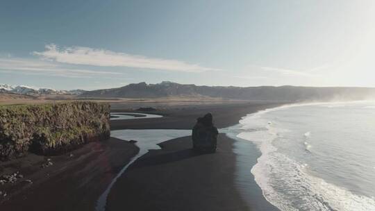 在火山海滩上破碎的海浪