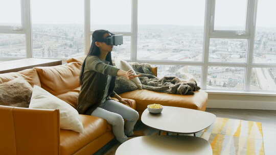 女人在客厅使用虚拟现实耳机视频素材模板下载