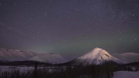 冬夜雪山的夜空星空和绿色北极光