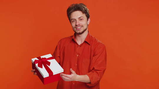 微笑的年轻人赠送生日礼物礼盒伸出手促销折