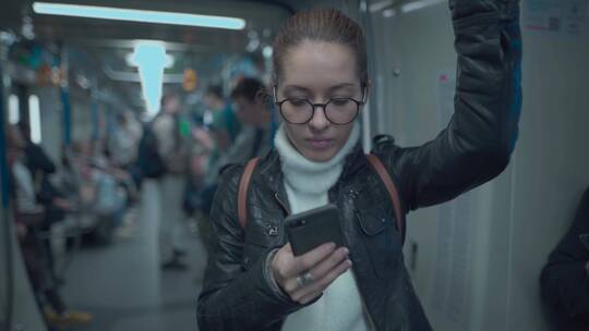 地铁上玩手机的女人
