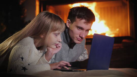 孩子们在篝火旁玩笔记本电脑