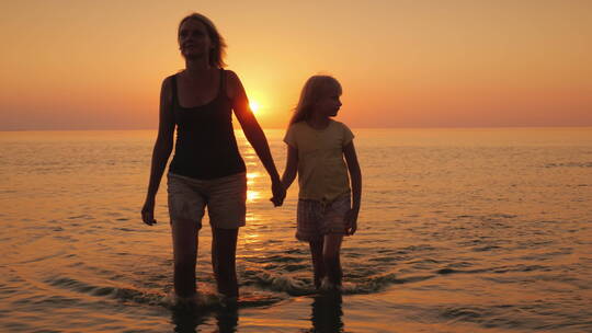 母女俩在落日的背景下散步视频素材模板下载