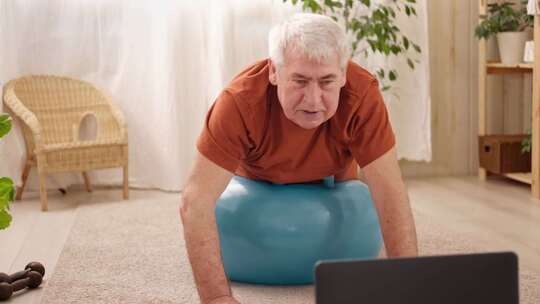 成熟的老人在家做健身锻炼体操在线课程与笔