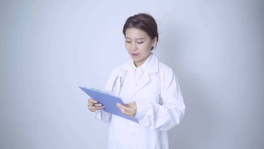 年轻女医生手持病历本书写记录视频素材模板下载