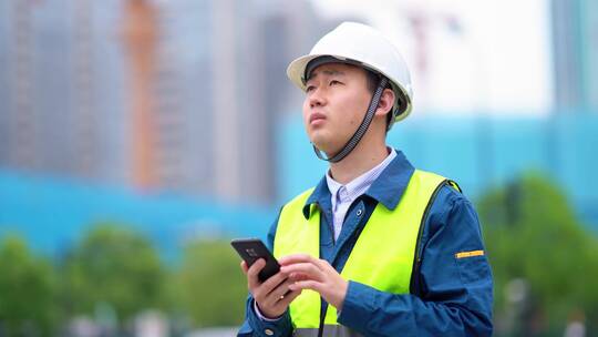 年轻工程项目经理施工现场使用手机指挥施工