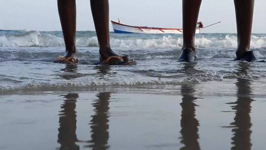 两个人站在海边的腿部镜头
