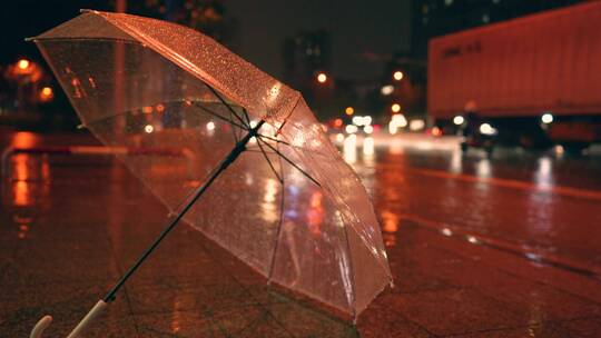 雨夜街道路灯下的透明雨伞4k视频素材